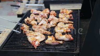在烧烤架上翻过来的鸡肉翅膀。 肉是用芒果烧烤架炒的。 烤架上的鸡肉